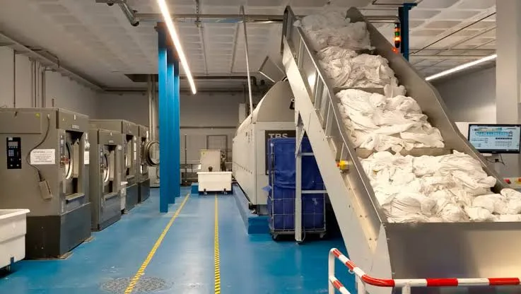 Textiles en una cinta transportadora de lavandería industrial